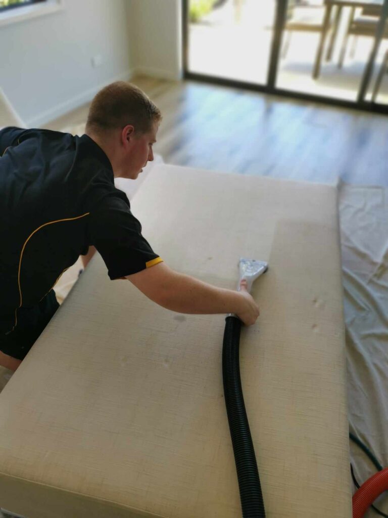 A man cleaning couch